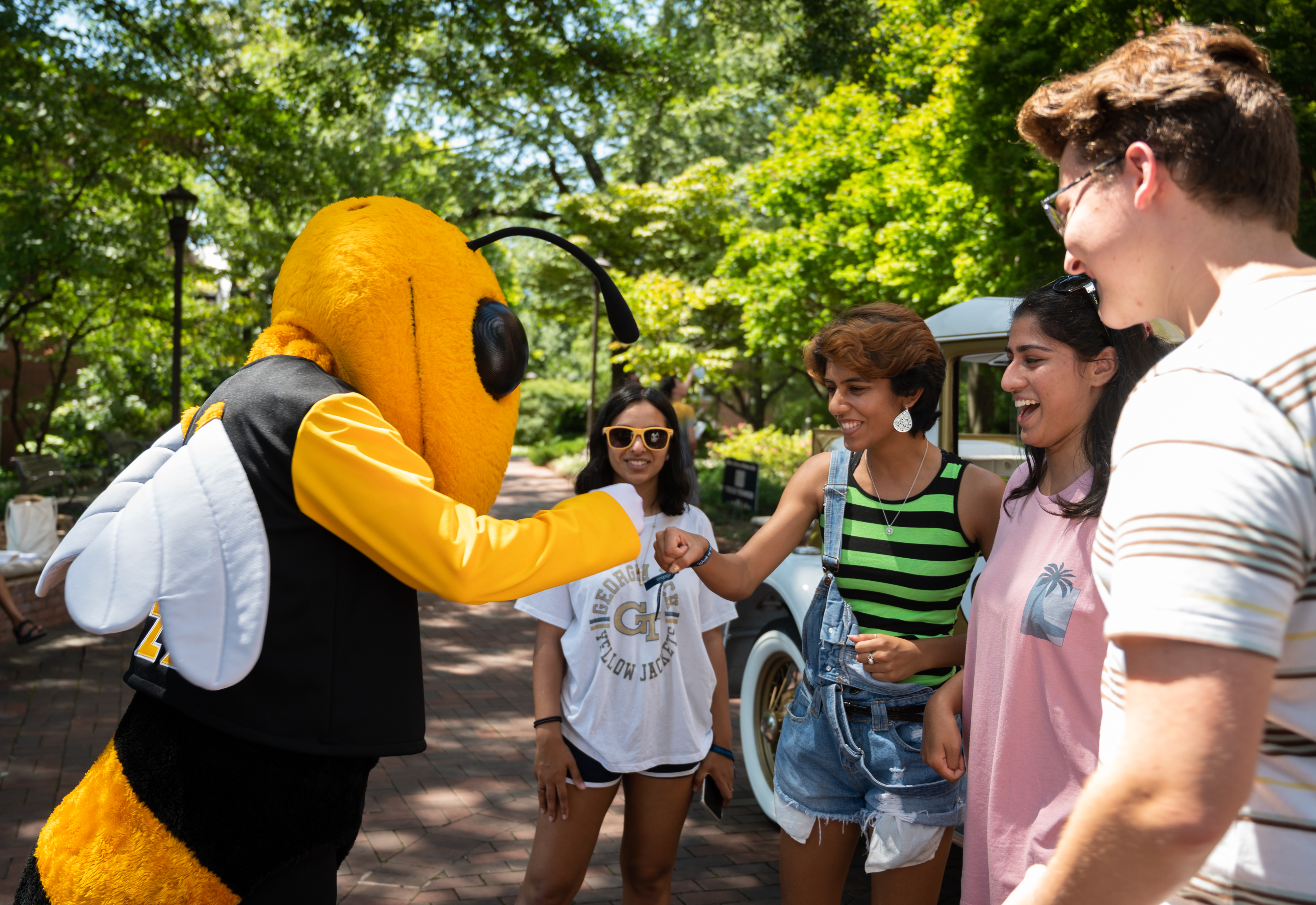 group of students fist bumping Buzz 