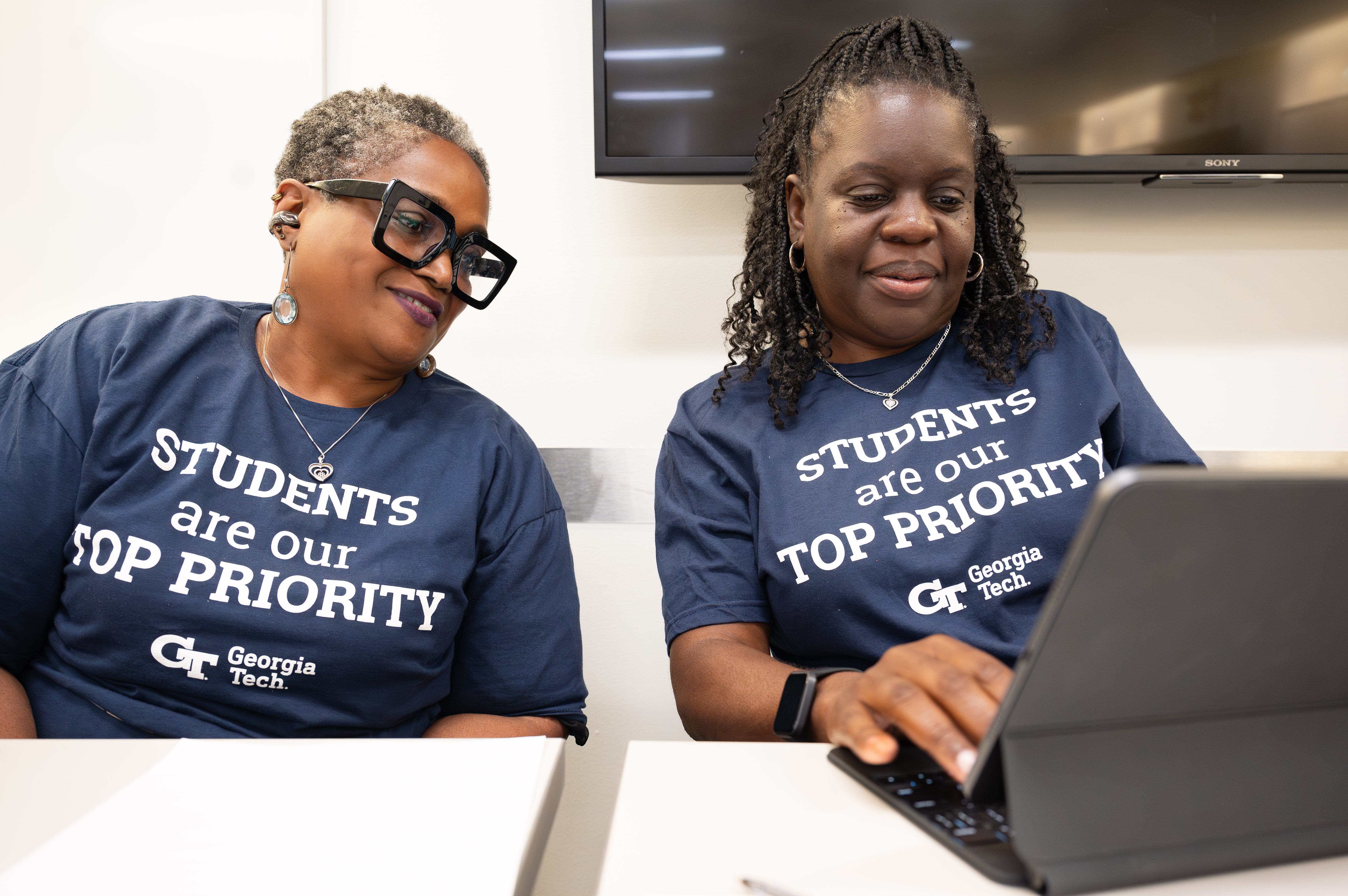 two staff members using a laptop