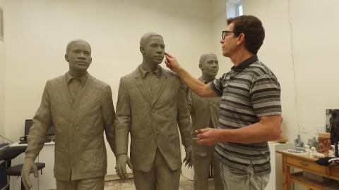 Atlanta sculptor Martin Dawe examines the molds.